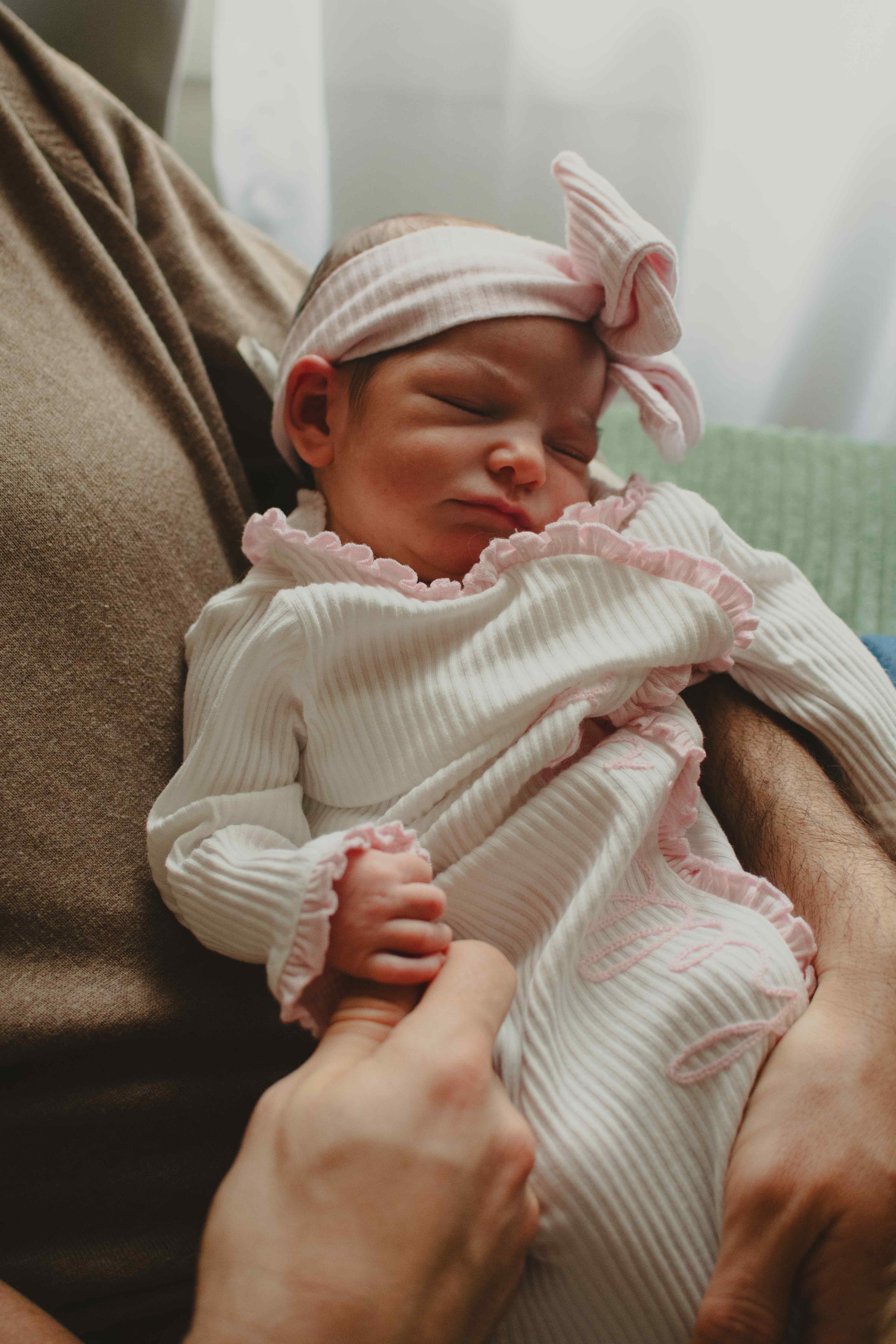 Sleeping newborn in pink striped outfit