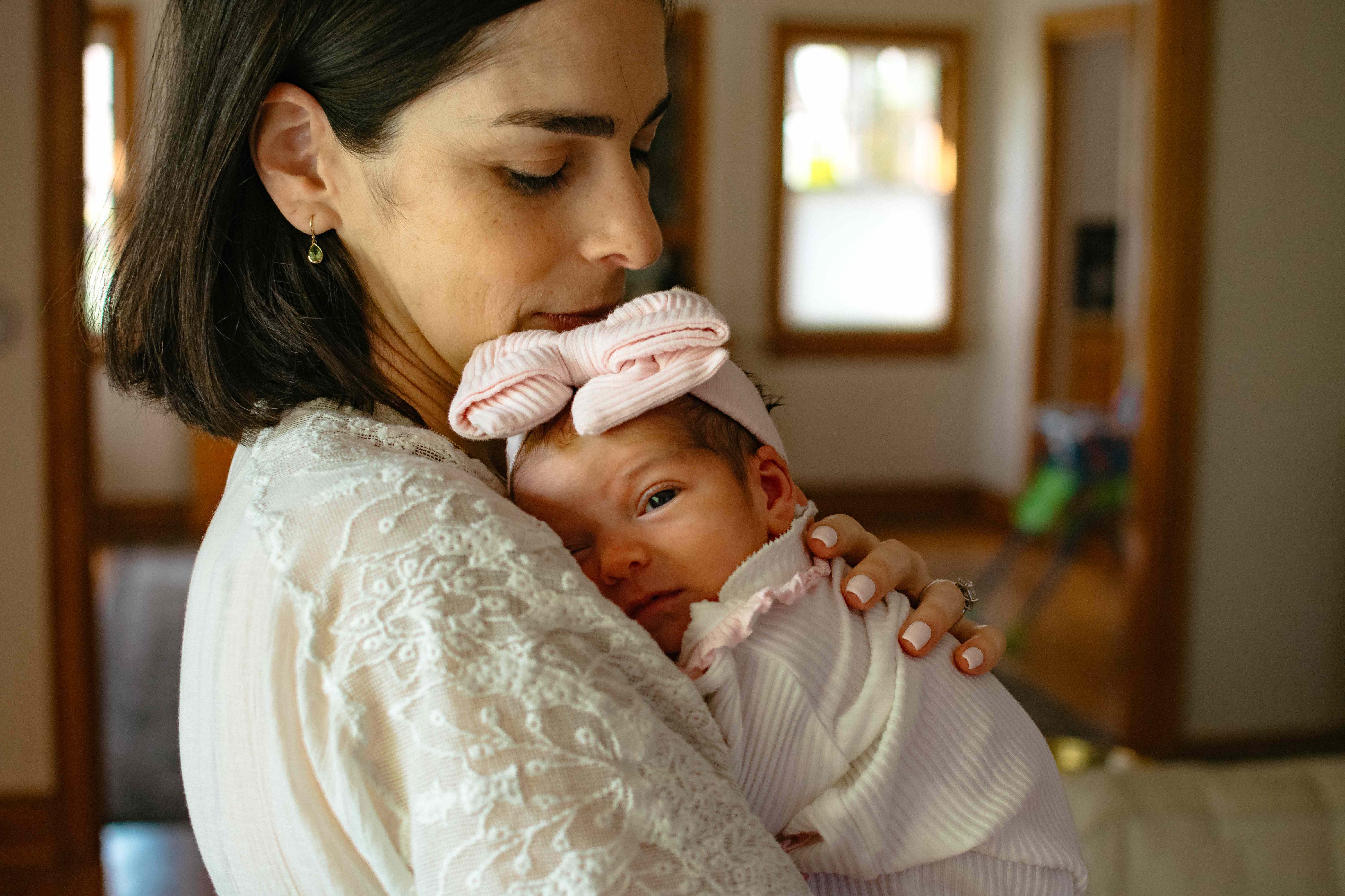 Mother in white holding newborn