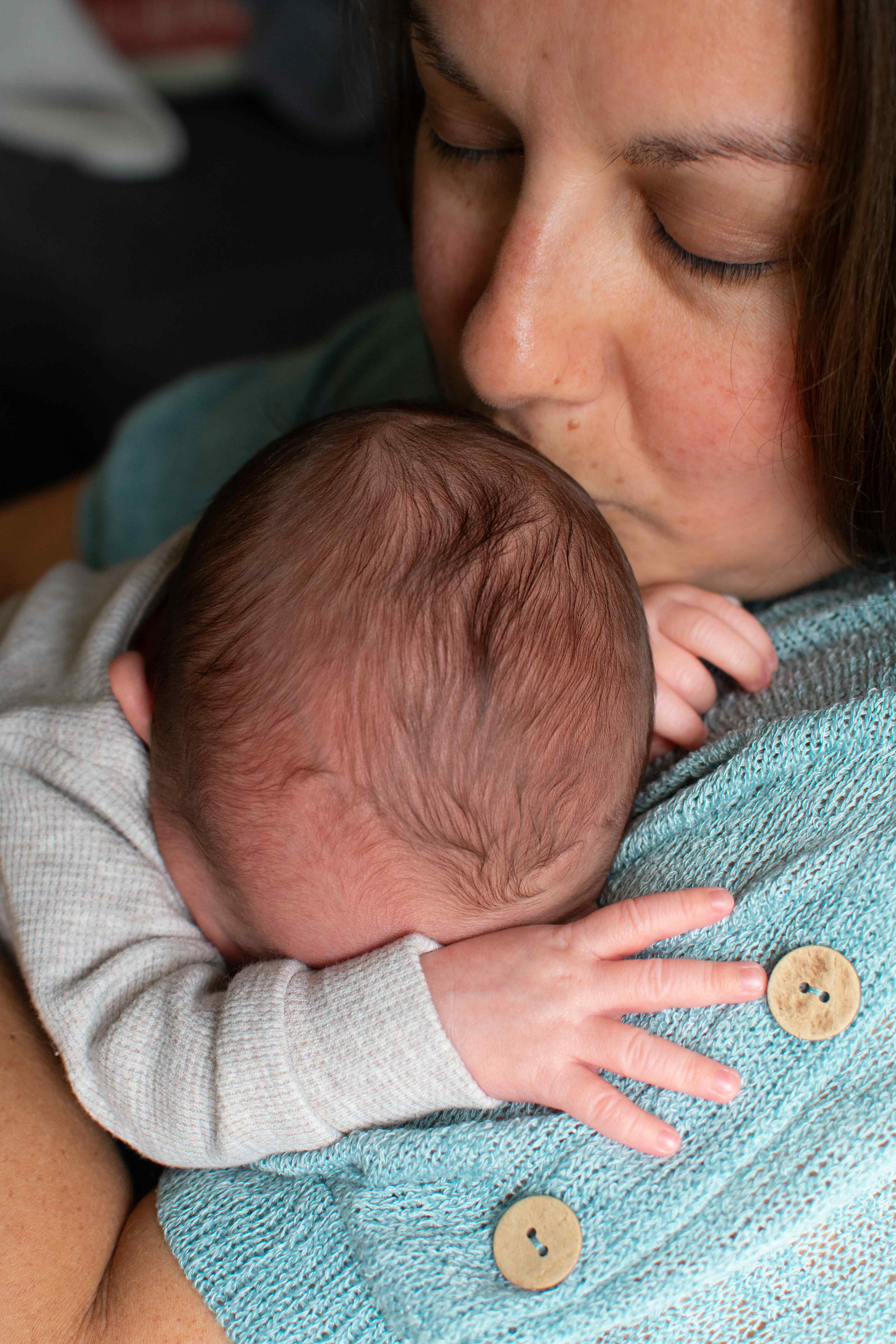 Mother kissing newborn closeup