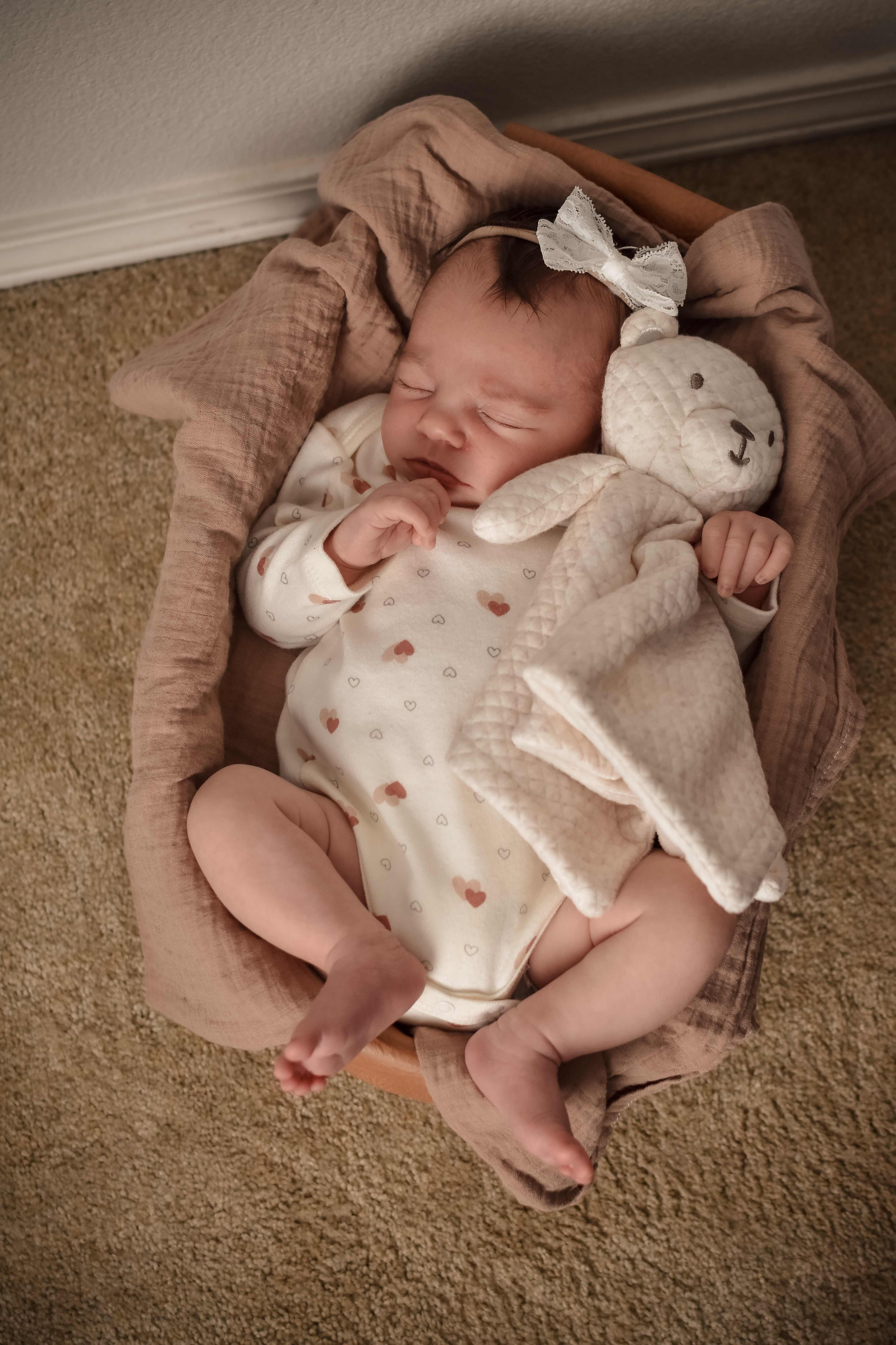 Newborn with bow and stuffed animal